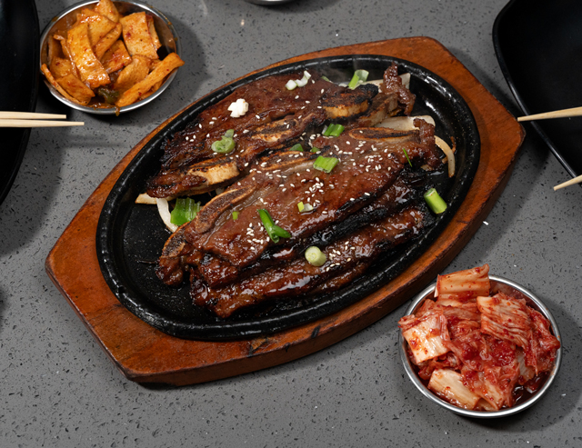 LA Kalbi (LA갈비), bone-in short rib, sweet soy marinade, sizzling on the cast iron.